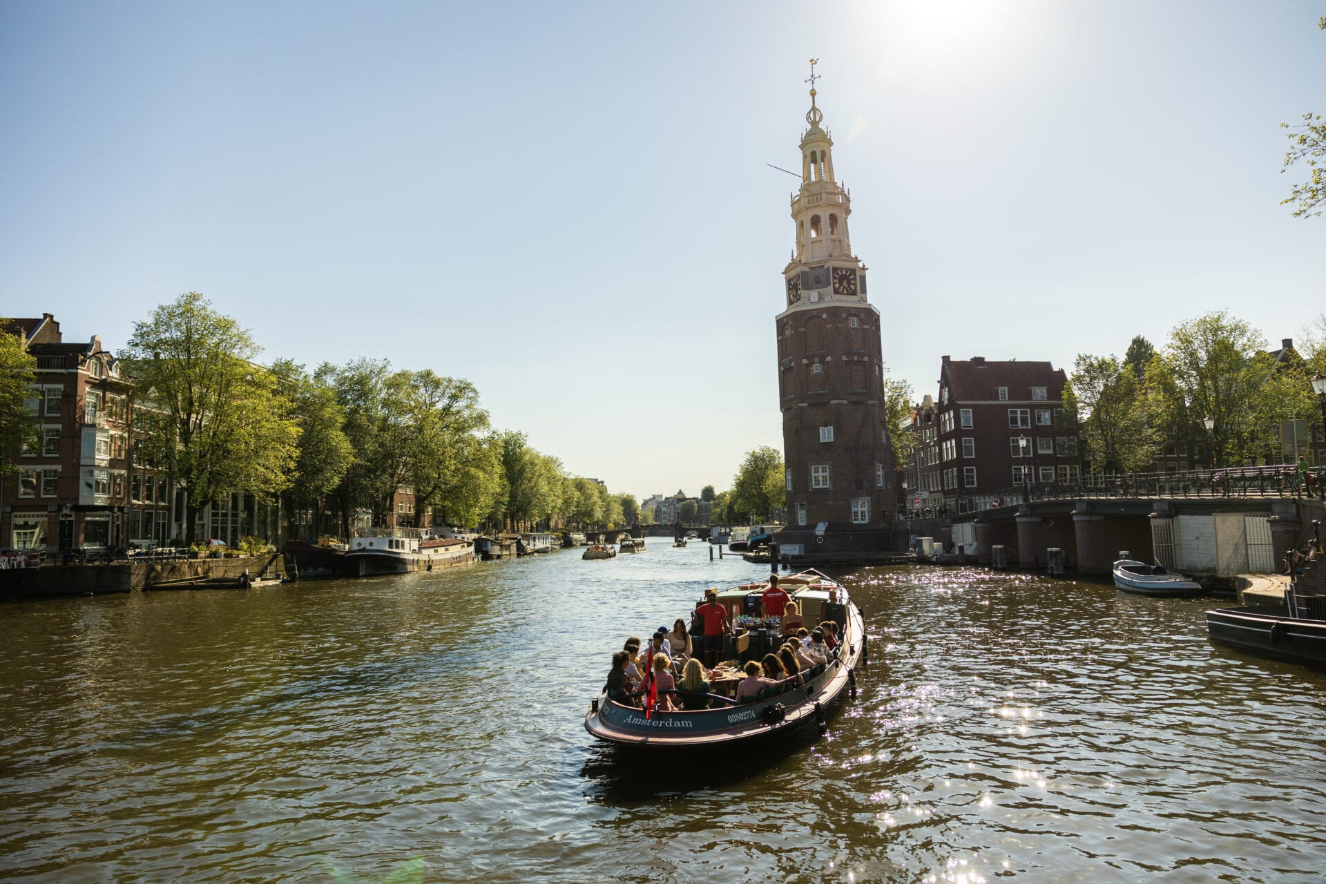 A canal cruise boat passing the Montelbaanstoren